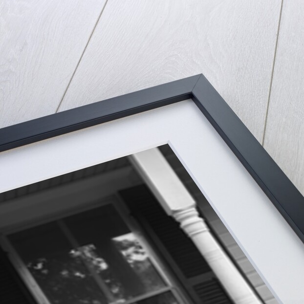 Couple man woman sitting on porch in rocking chairs holding newspapers up hiding their faces by Anonymous