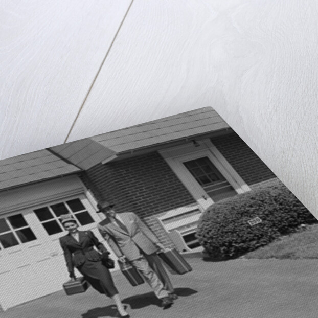 Couple carrying luggage walking towards convertible car in driveway by Anonymous