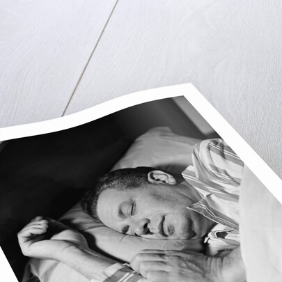 Man asleep sleeping in bed wearing pajamas by Anonymous