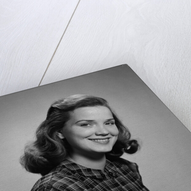 Young smiling woman holding books looking at camera by Anonymous