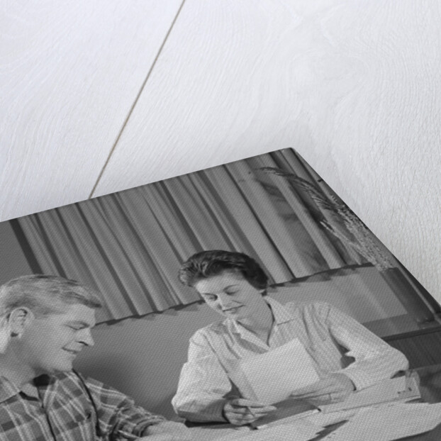 Couple man woman at table working on household accounts bills by Anonymous