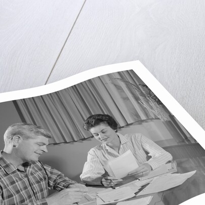 Couple man woman at table working on household accounts bills by Anonymous