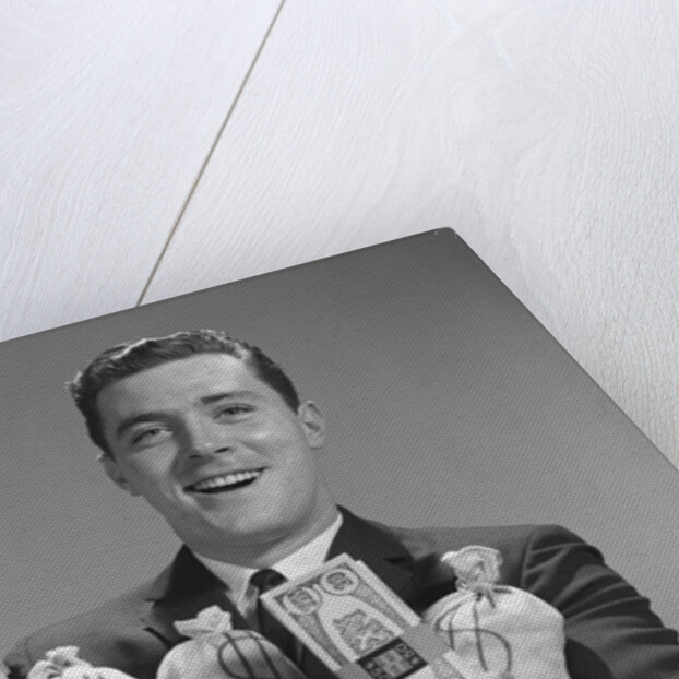 Smiling man holding money bags and bundles of cash by Anonymous