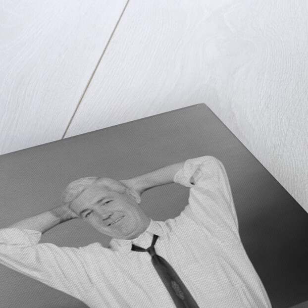 Smiling man working on family budget papers at desk by Anonymous