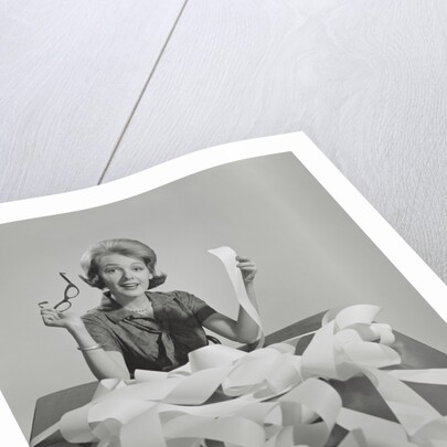 Woman holding eyeglasses and end of extremely long tape from office machine by Anonymous