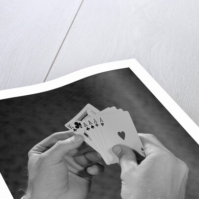 Male hands holding hand poker cards 4 aces and a king by Anonymous