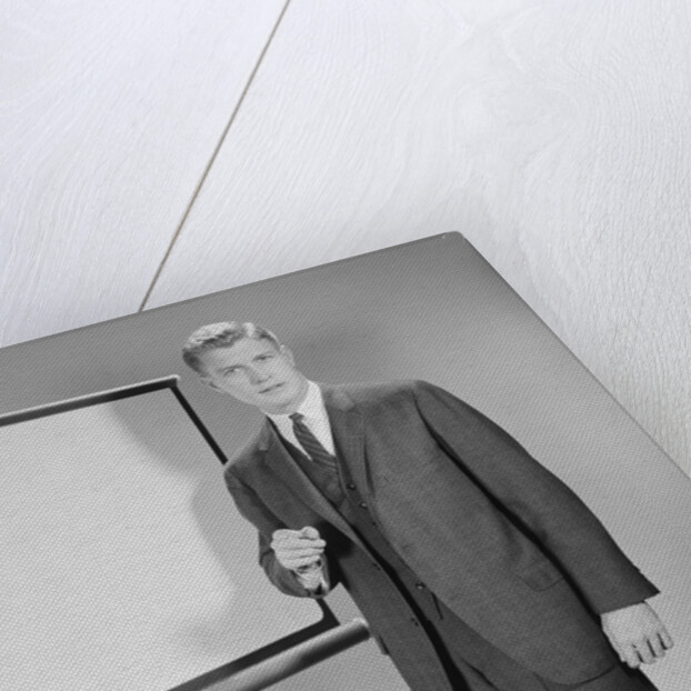 Man standing beside blank screen ready for presentation by Anonymous