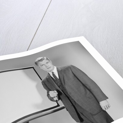 Man standing beside blank screen ready for presentation by Anonymous