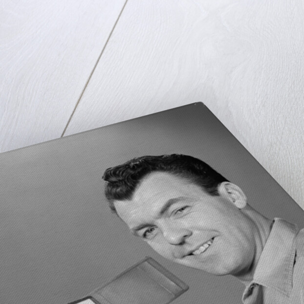 Smiling man holding up wallet with picture of wife and daughter by Anonymous