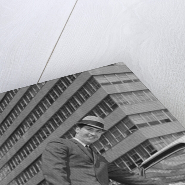 Businessman carrying briefcase getting into car on urban street by Anonymous