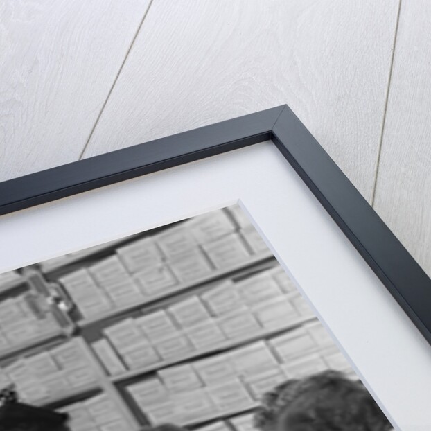 Family mother two children in shoe store trying new shoes helped by salesman by Anonymous