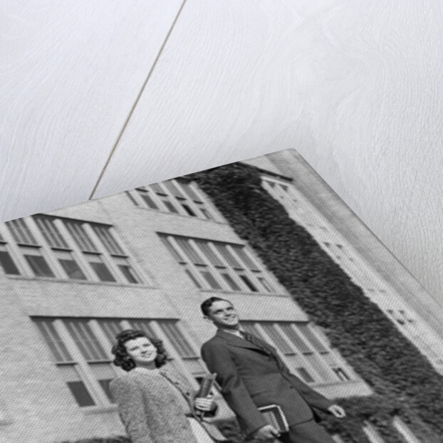 College couple walking on campus before ivy covered building by Anonymous