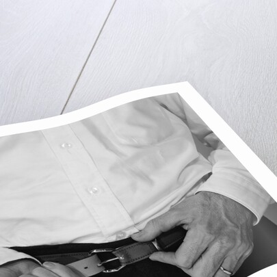 Man hands tightening belt by Anonymous