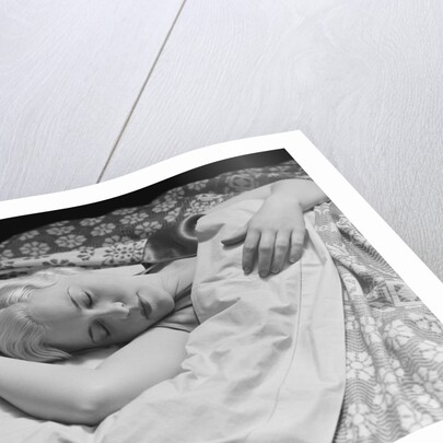 Sleeping blond woman hand over head asleep by Anonymous