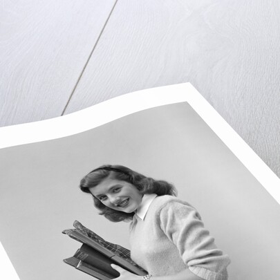 Smiling brunette teen student wearing sweater carrying school books by Anonymous