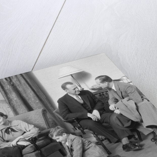 Family mother father two kids playing on floor visiting with another couple by Anonymous
