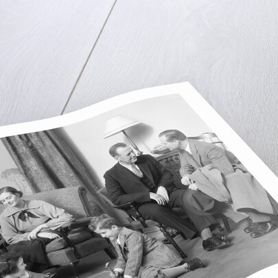 Family mother father two kids playing on floor visiting with another couple by Anonymous