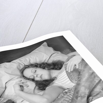 Woman sleeping asleep in bed alarm clock on night table by Anonymous