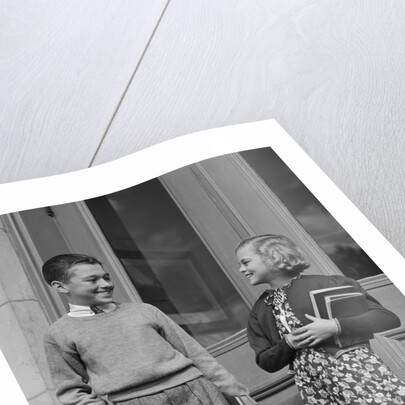 Smiling boy & girl holding school books by doors by Anonymous