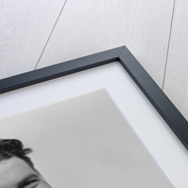Smiling curly hair man wearing apron taking order with pencil and note pad by Anonymous