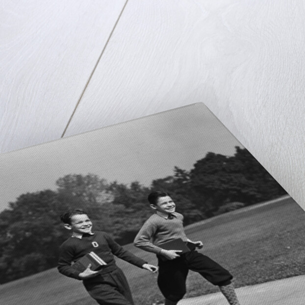 Two smiling boys running carrying school books by Anonymous