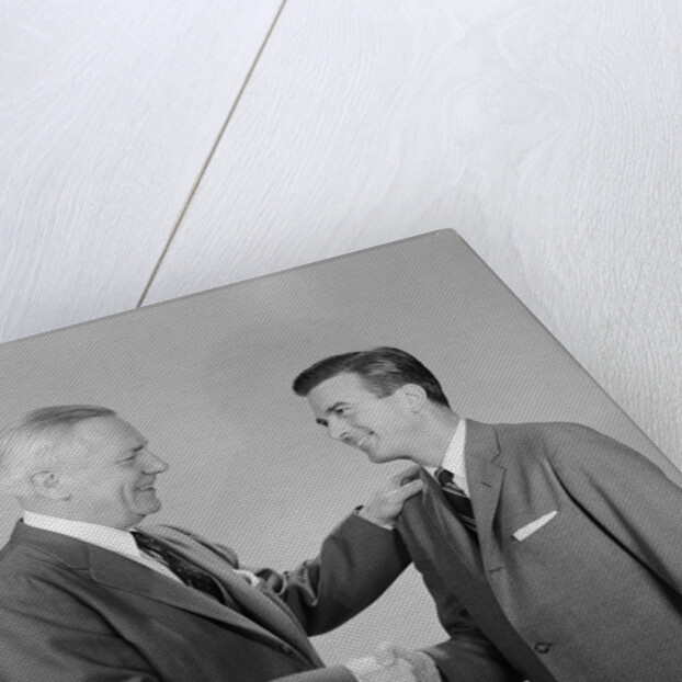Older and younger business men shaking hands by Anonymous