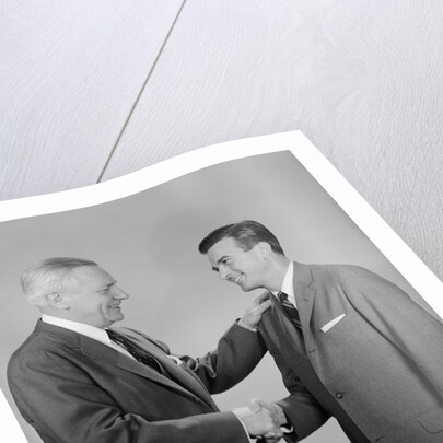 Older and younger business men shaking hands by Anonymous