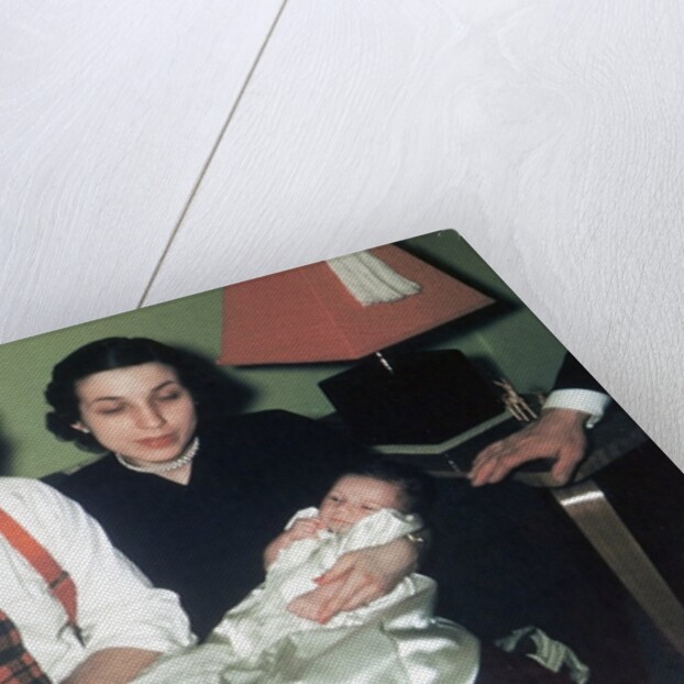 Young couple holding baby boy in christening gown, ca. 1952 by Anonymous