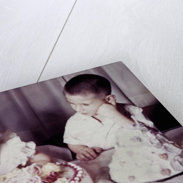 Brother watches his sister blow out candles on birthday cake, ca. 1956 by Anonymous