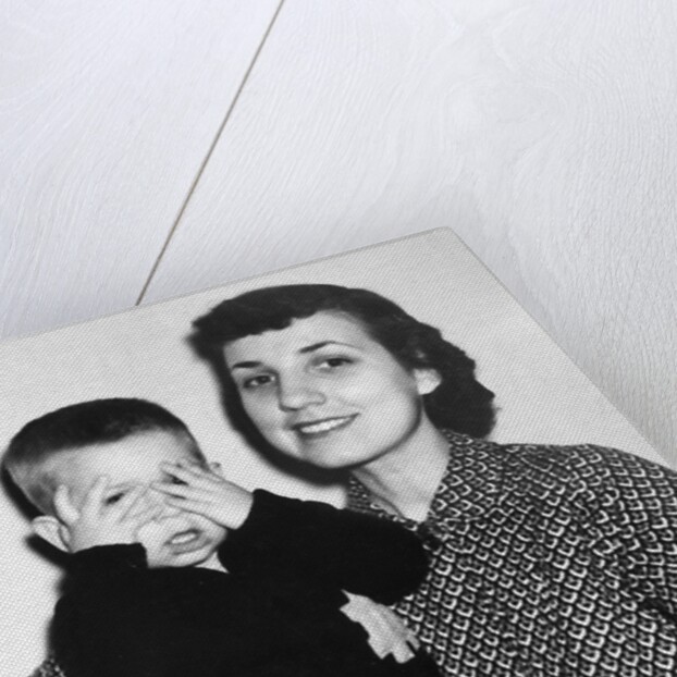 Mother holding son playing peek-a-boo, ca. 1955 by Anonymous