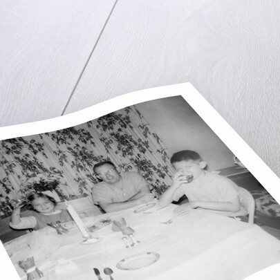 Father with children at the dinner table, ca. 1962 by Anonymous