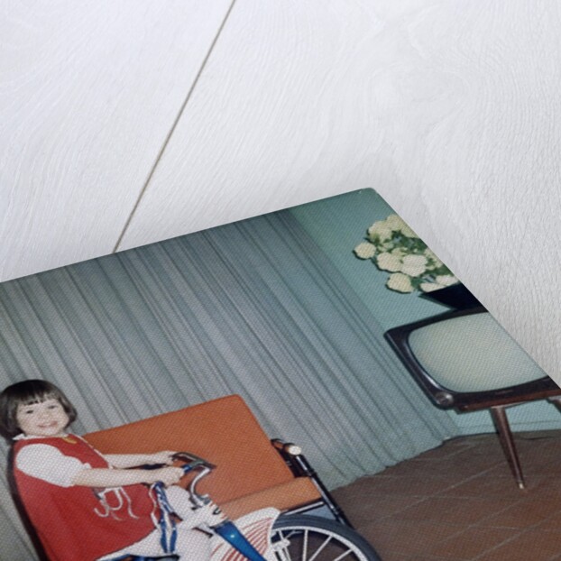 Young girl rides her new tricycle in the house, ca. 1967 by Anonymous