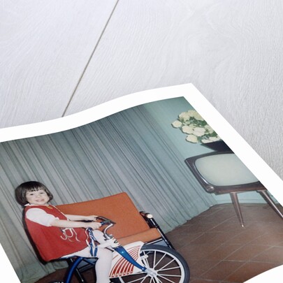 Young girl rides her new tricycle in the house, ca. 1967 by Anonymous