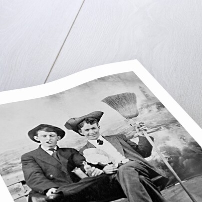 Two young men on a bench with a broom, ca. 1900 by Anonymous