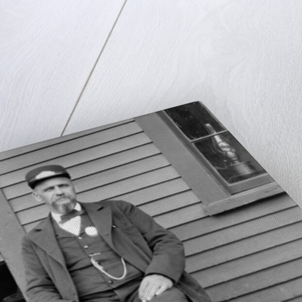 Station master sits at the train depot, ca. 1900. by Anonymous