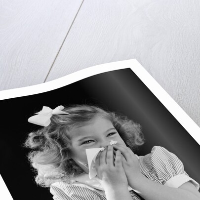 1940s little blond girl ribbon in hair holding tissue to nose sneezing by Anonymous