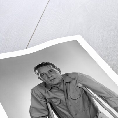 1960s man walking on crutches looking at camera by Anonymous