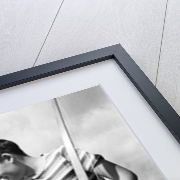 1960s boy jeans striped t-shirt holding bow & pulling arrow out of target bull's-eye by Anonymous