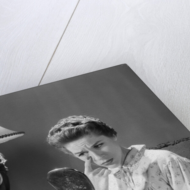 1950s 1960s woman in nightgown holding mirror look at eye wrinkles aging beauty cosmetic serious concerned expression by Anonymous