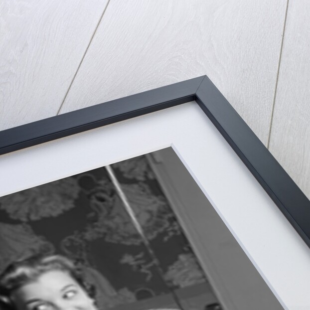 1950s smiling woman looking into bathroom mirror brushing teeth by Anonymous