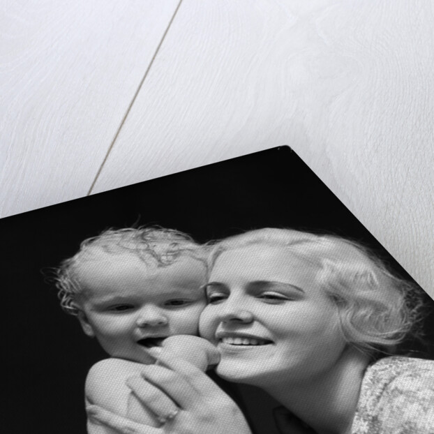 1930s blonde woman mother smiling holding baby to cheek by Anonymous