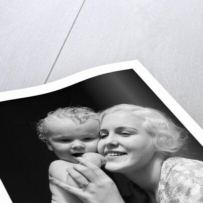 1930s blonde woman mother smiling holding baby to cheek by Anonymous