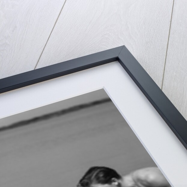 1930s family father mother daughter son with rubber inner tube wading in seashore water by Anonymous