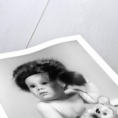 1960s baby wearing coonskin hat by Anonymous