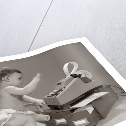 1960s baby seated in small chair hitting keys on office adding machine on top of small file drawers by Anonymous