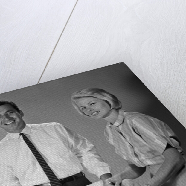 1960s smiling mother and father with twin babies on diaper changing table looking at camera by Anonymous