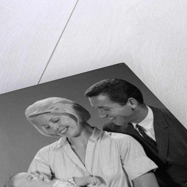 1960s happy mother and father smiling at their baby by Anonymous