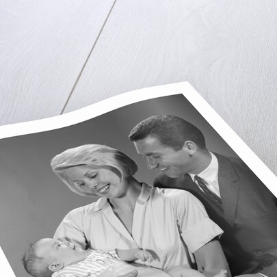 1960s happy mother and father smiling at their baby by Anonymous