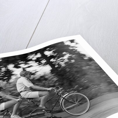 1970s teenage girl and boy riding bicycle built for two by Anonymous
