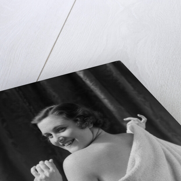 1930s smiling brunette woman looking over shoulder drying back with towel looking at camera by Anonymous